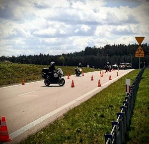 Policyjni motocykliści jeżdżą po torze przeszkód.