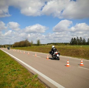 Policyjni motocykliści jeżdżą po torze przeszkód.