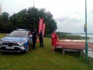 samochód i ludzie na brzegu jeziora