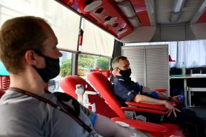 Dwie osoby siedzą na fotelach i oddają krew