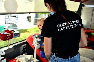 Osoba  siedzi na fotelu i oddaje krew