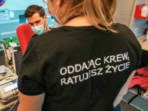 Policjanci i pracownicy policji oddają krew w krwiobusie.