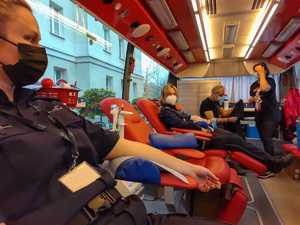 policjanci i pracownicy oddają krew, krwiobus