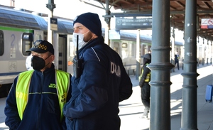 policjant ze strażnikiem miejskim na dworcu