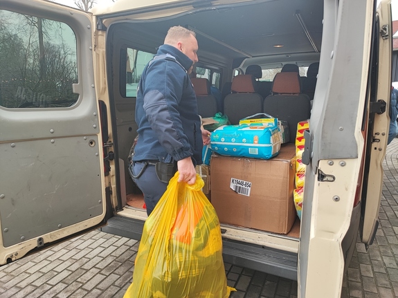 policjant wkłada paczki do busa