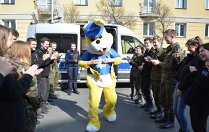 maskotka policus obok w szeregu uczniowie