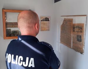 Policjant oglądający gablotę z odkrytymi eksponatami podczas remontu