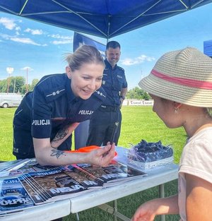 policjantka wręcza dziecku upominek