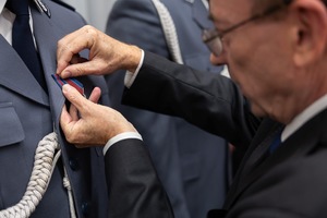 minister Kamiński przypina medal policjantowi