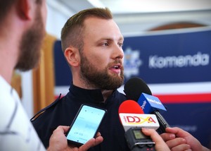 Zdjęcie: policjant wypowiada się do mikrofonu.