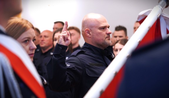 Zdjęcie: policjant ślubuje na sztandar.