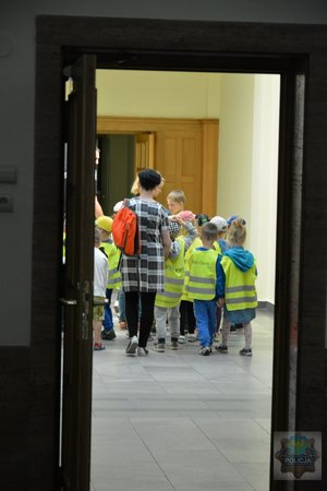 zwiedzający idą jednym z korytarzy komendy
