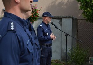 na pierwszym planie policjanci z nowo otwartego komisariatu w tle przemawia gen. Szymczyk