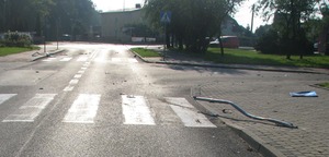 zniszczone znaki drogowe i strzępy karoserii samochodowej na drodze
