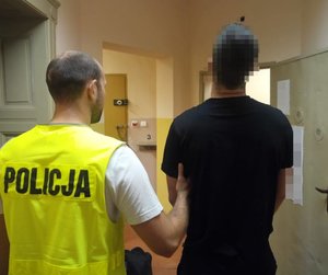 policjanci prowadzą zatrzymanego mężczyznę