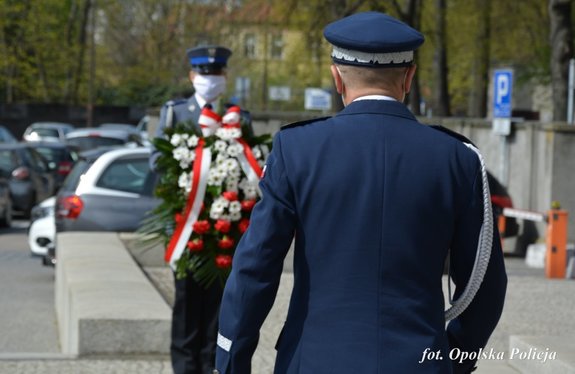 komendant wojewódzki policji składa wieniec pod tablicą pamiątkową