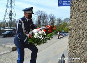 komendant wojewódzki policji składa wieniec pod tablicą pamiątkową