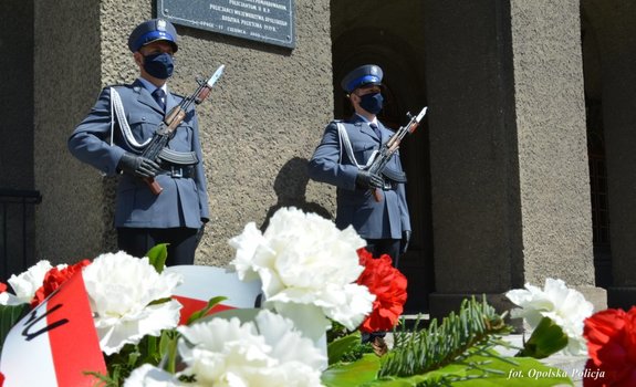 2 policjantów stoi przed tablicą pamiątkową