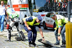 policjant przenosi pachołek na drodze