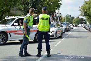 policjant stoi na drodze i rozmawia z jednym z organizatorów