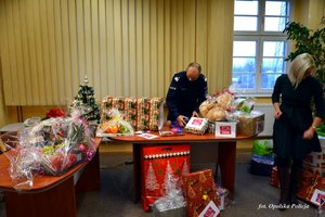 policjant i pracownica cywilna pakują prezenty