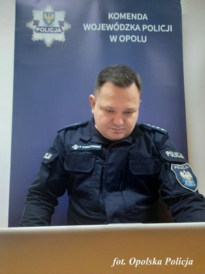 policjant siedzi przed komputerem