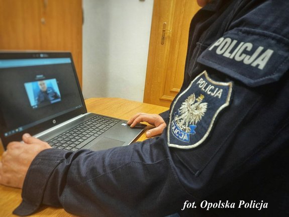 policjant siedzi przed komputerem