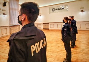 w jednym rzędzie stoją policjanci w tle napis &quot;Komenda Wojewódzka Policji w Opolu&quot;