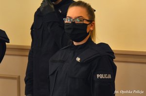 policjantka stoi na tle ściany