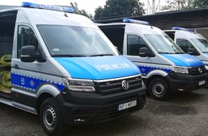 trzy radiowozy stoją obok siebie. Mają otwarte drzwi tylne wewnątrz widać rożny sprzęt wykorzystywany przez policjantów