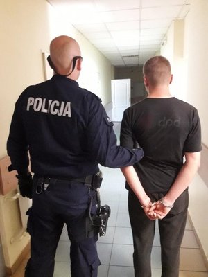 zatrzymany mężczyzna, prowadzony przez policjanta